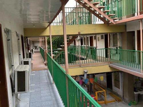 an empty hallway of a building with green railing at hotel mexico in Mexicali