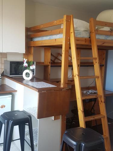 un lit en mezzanine dans une cuisine avec un bureau dans l'établissement Studio Paris Nation-Bastille, à Paris