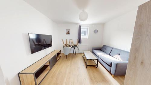 un salon avec un canapé et une télévision dans l'établissement 4ème étage, Général Sarrail, au Havre