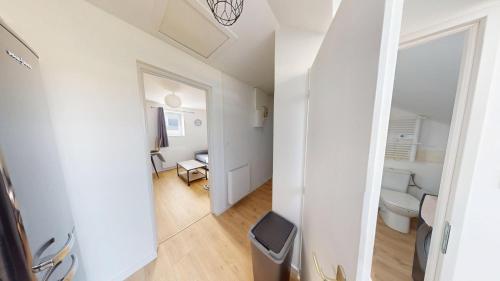 une petite pièce blanche avec des toilettes et un couloir dans l'établissement 4ème étage, Général Sarrail, au Havre