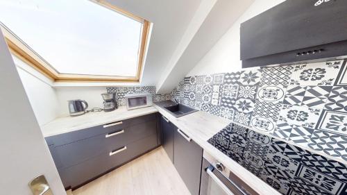 - une cuisine avec du carrelage noir et blanc sur le mur dans l'établissement 4ème étage, Général Sarrail, au Havre