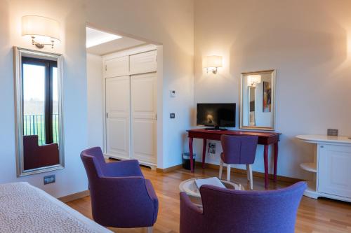a room with a table and chairs and a desk at Borgo La Chiaracia Resort & SPA in Castel Giorgio