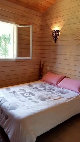 - une chambre avec un grand lit dans une cabane en rondins dans l'établissement Maison chalet Soustons, à Soustons