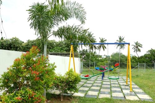 a boy playing on a swing set in a yard at Riverfront Villa, Kanyakumari - 1 BH in Kanyakumari