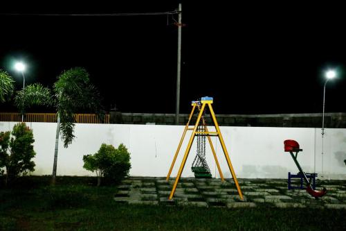 a swing set in front of a wall at night at Riverfront Villa, Kanyakumari - 1 BH in Kanyakumari