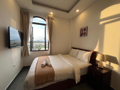 a bedroom with a large bed with a window at Amelia House - Boutique Hotel in Khu Chi Lăng