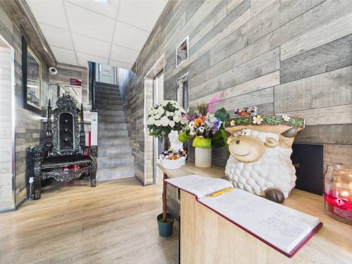 a room with a desk with a book and a sheep statue at Kings Boutique Hotel in Blackpool