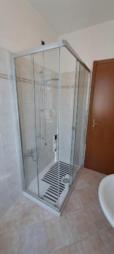 una ducha de cristal en un baño con lavabo en La Camelia, en Ameglia