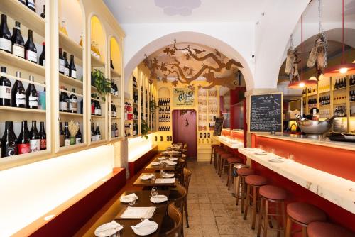 a restaurant with long tables and chairs and wine bottles at Hermitage Castelo - Casa Sé in Lisbon