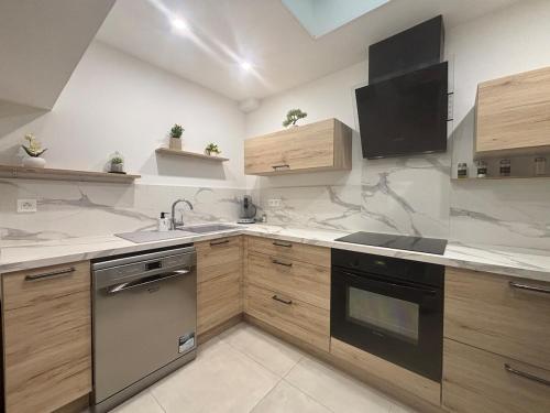 une cuisine avec un évier et une cuisinière four supérieur dans l'établissement Chez Cricri, modern accommodation, à Bizanet