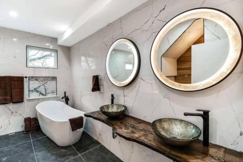 a bathroom with two sinks and a large mirror at Emerald Jacuzzi Loft in Philadelphia