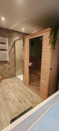 - un sauna avec une porte en verre dans la pièce dans l'établissement Jungle Room - Sauna, Jacuzzi, Cinéma - Hyper Centre, à Troyes