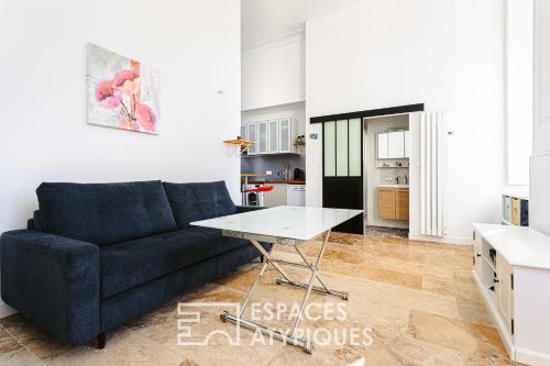 un salon avec un canapé bleu et une table dans l'établissement Appartement avec jardin dans un château, à Lagord