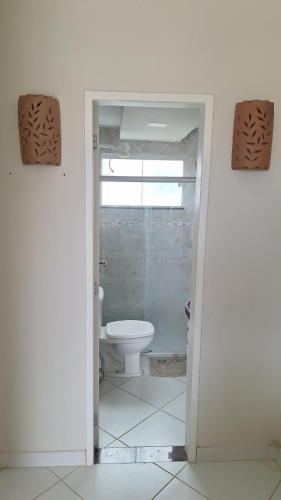 a bathroom with a white toilet and a window at Flat Mar doce lar in Conde