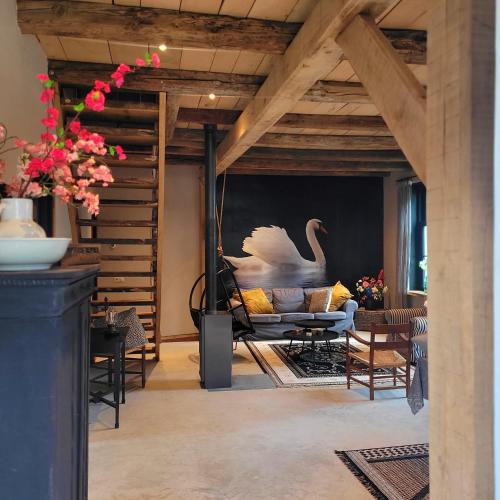 a living room with a couch and a table at Logeerderij Het Landleven met jacuzzi en Finse sauna Achterhoek in Vragender