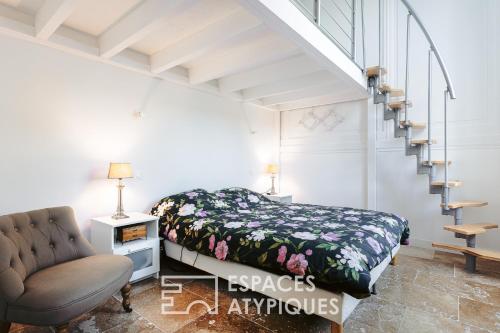 une chambre avec un lit et un escalier dans l'établissement Appartement avec jardin dans un château, à Lagord