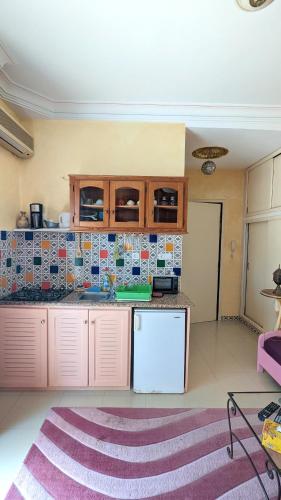 a kitchen with pink cabinets and a counter top at Dar El Amen Appartements in Mahdia