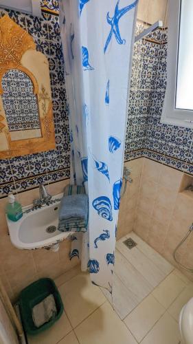 a bathroom with a shower and a sink and a shower curtain at Dar El Amen Appartements in Mahdia