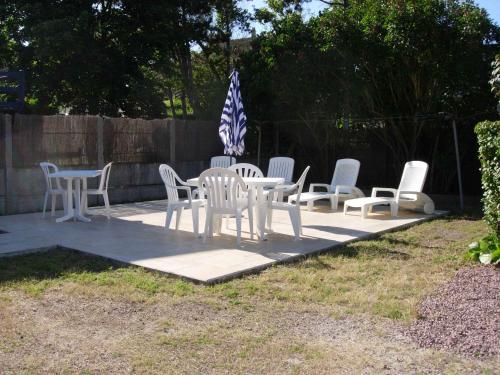 - un ensemble de chaises et de tables blanches sur une terrasse dans l'établissement Les MOUSSES, à Varaville