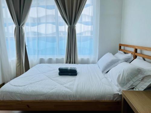 a bedroom with a white bed with a window at Luxury 2BR at Heart of Melaka in Melaka