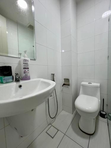 a white bathroom with a sink and a toilet at Luxury 2BR at Heart of Melaka in Melaka