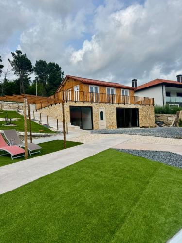 a brick building with a lawn in front of it at Casinhas do Marão in Parada