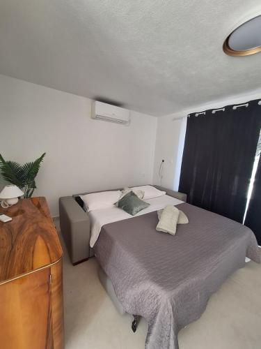 Un dormitorio pequeño con una cama y una cómoda. en Smokvica, en Senj