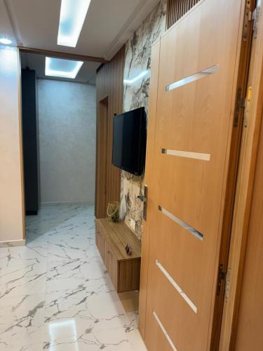 a room with a tv on a wall and a door at The gray pearl in Agadir