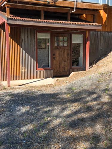 a house with a wooden door on a hill at Kennymores Grill and Lodging in Cedaredge