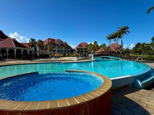 a large swimming pool at a resort with palm trees at Studio Evasion Coco vue Jardin Tropical - Pierre & Vacances in Sainte-Luce