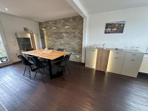 a kitchen and dining room with a wooden table and chairs at Ferienhaus EifelJECK in Blankenheim