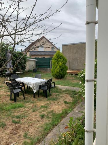 - une table de pique-nique et des chaises dans la cour dans l'établissement Maison GROSBOIS, à Arnage