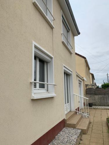 un bâtiment avec des fenêtres blanches sur son côté dans l'établissement Maison GROSBOIS, à Arnage