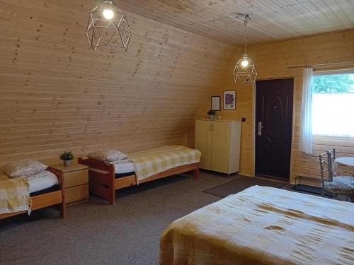 a room with two beds and a window at Zakątek Włóczykija in Cisna
