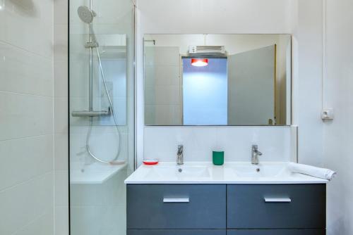 une salle de bain avec un lavabo, un miroir et une douche dans l'établissement Grand T5 de 103 m2 au Bd Guigou avec 4 balcons, à Marseille