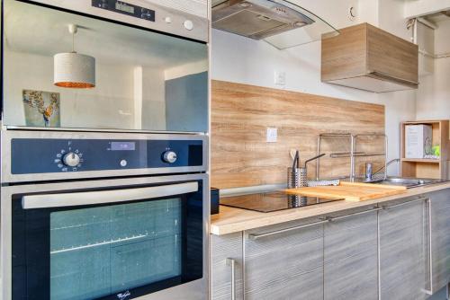 une cuisine avec une cuisinière et un évier dans l'établissement Grand T5 de 103 m2 au Bd Guigou avec 4 balcons, à Marseille
