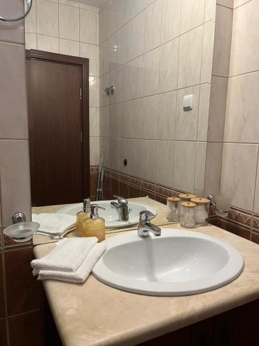a bathroom with a white sink and a mirror at Kaliakria Vibes studio apartment in Topola