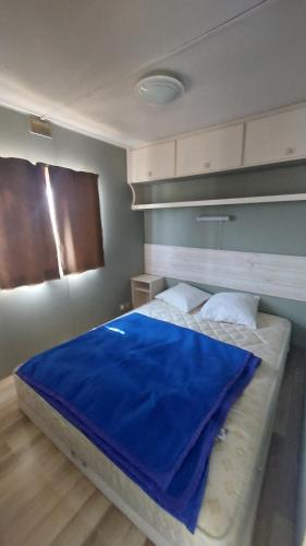 - une chambre avec un lit doté d'une couverture bleue dans l'établissement Logement dans propriété, à Saint-Laurent-dʼAigouze