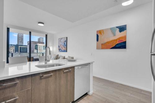 een witte keuken met een wastafel en een raam bij Best Location 2 bedrooms 2 bathrooms in Miami