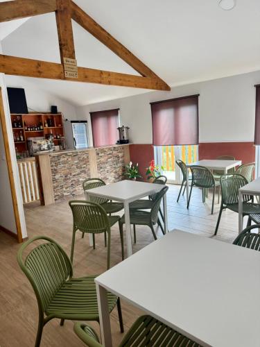 a dining room with tables and green chairs at Casinhas do Marão in Parada