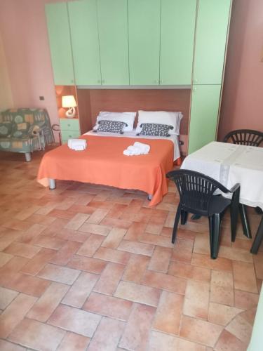 a bedroom with two beds and a table and chairs at Casa del dottore in Cefalù