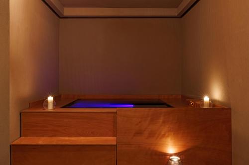 Un jacuzzi en una habitación con dos velas. en Infinity View Hotel Tinos, en Tinos