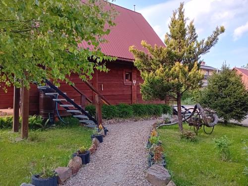 a path in front of a red barn at Zakątek Włóczykija in Cisna