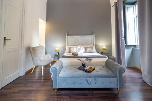 a bedroom with a bed and a chair in it at Le suite di Alba in Palermo