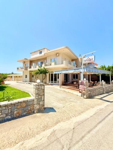 a large building with a sign in front of it at Avenue Hotel Falassarna in Falasarna
