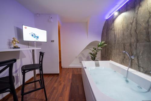 a bathroom with a bath tub and a bar with a stool at Le suite di Alba in Palermo