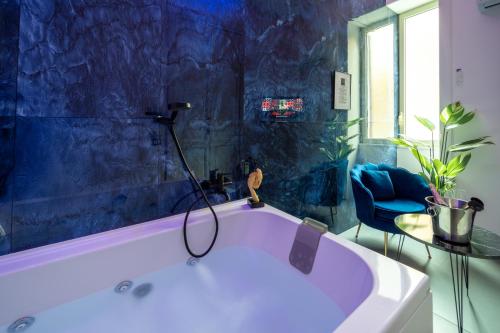 a bath tub in a bathroom with a blue wall at Le suite di Alba in Palermo
