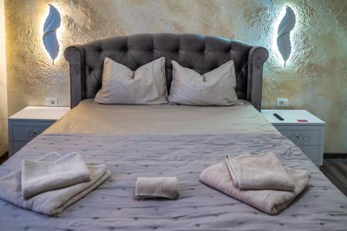 1 cama con 2 almohadas y toallas en Răsărit la Mare, en Constanţa