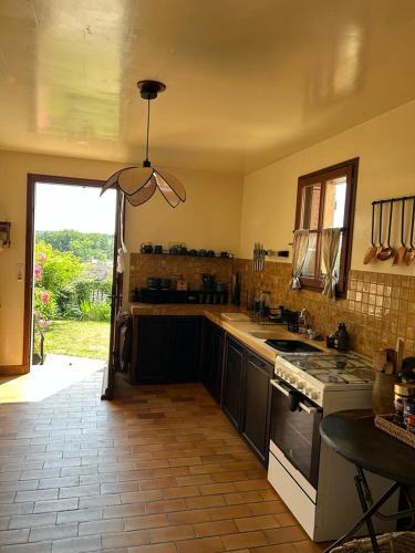 une cuisine avec un évier et une cuisinière dans l'établissement La maison du rempart, à Sainte-Sévère-sur-Indre