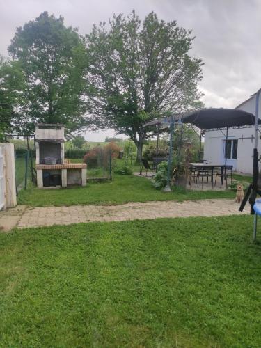 a yard with a picnic table and an umbrella at maison à la campagne in Sauveterre-de-Guyenne